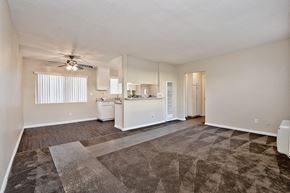 Orange apartment for rent - an empty living room and kitchen with a ceiling fan