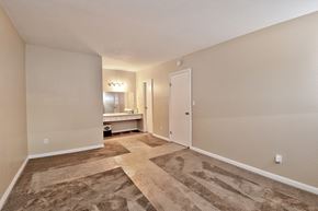 Orange apartment for rent - a spacious living room with a door to a bathroom