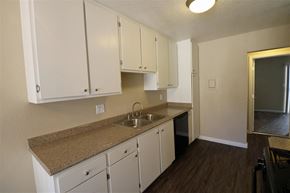 Orange apartment for rent - an empty kitchen with white cabinets and a sink