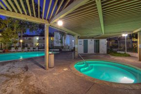 Anaheim apartment for rent - a resort style swimming pool with a hot tub at night