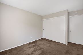 Anaheim apartment for rent - a bedroom with carpet and white walls and doors