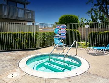 Garden Grove apartment for rent - a hot tub and chairs in a pool in front of a house