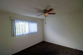 Tustin apartment for rent - a living room with a ceiling fan and a window