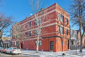 Chicago apartment for rent - a red brick building with cars parked in front of it