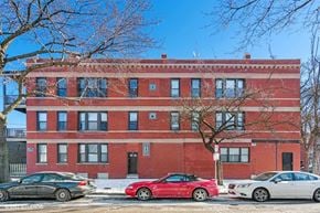 Chicago apartment for rent - a red brick building with cars parked in front of it