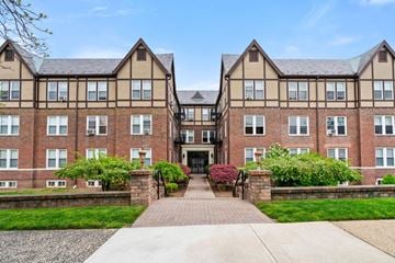 Cranford apartment for rent - front view of an apartment building with a walkway and grass
