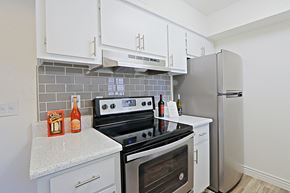 Glendale apartment for rent - a kitchen with stainless steel appliances and white cabinets at Spring Meadow Apartments, Glendale, AZ