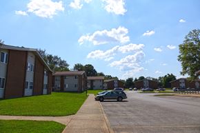 Murfreesboro apartment for rent - a car parked in a parking lot in front of apartment buildings