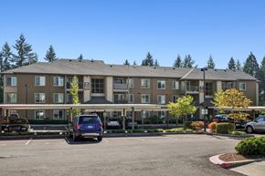 Happy Valley apartment for rent - A large building with a parking lot in front of it.