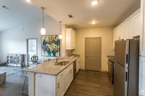 Brentwood apartment for rent - A kitchen with white cabinets and a brown refrigerator.