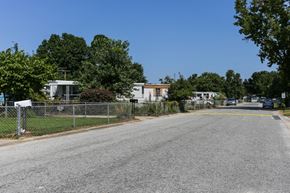 Chesapeake apartment for rent - A street with a fence and trees on the side.