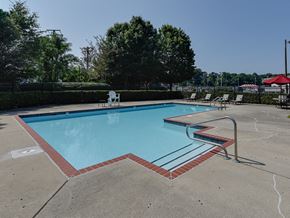 Suffolk apartment for rent - a swimming pool with chairs and a fence around it