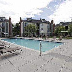 Littleton apartment for rent - a swimming pool with chaise lounge chairs in front of a building