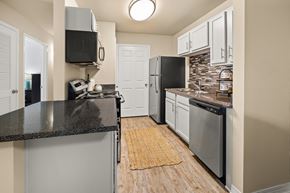 Biloxi apartment for rent - A kitchen with a black counter top and stainless steel appliances.