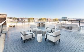 Sioux City apartment for rent - a rooftop patio with couches and chairs and a fire pit