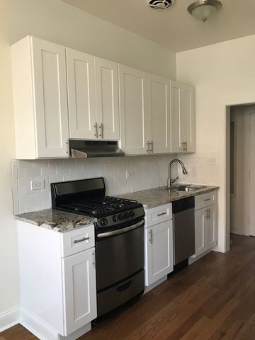 Evanston apartment for rent - a kitchen with white cabinets and a stove and a sink