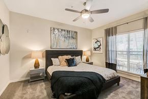 Coppell apartment for rent - a bedroom with a bed and a ceiling fan