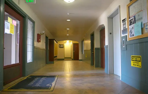 Oakland apartment for rent - a hallway with many doors and a yellow sign on the floor