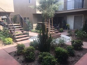 Downey apartment for rent - a courtyard with stairs and landscaping in front of a building