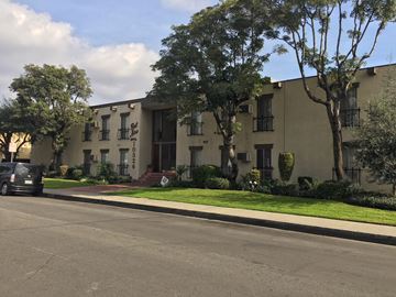 Downey apartment for rent - an apartment building on a street with a car parked in front