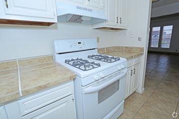 Las Vegas apartment for rent - A white gas stove in a kitchen with beige tiles.