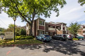 Charlotte apartment for rent - a parking lot with cars in front of an apartment building