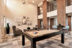 Phoenix apartment for rent - A pool table in a room with a high ceiling and a chandelier.