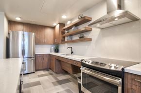 Phoenix apartment for rent - A modern kitchen with a stainless steel refrigerator and a stove top oven.