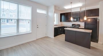 Windsor Mill townhouse for rent - A kitchen with black cabinets and a white door.