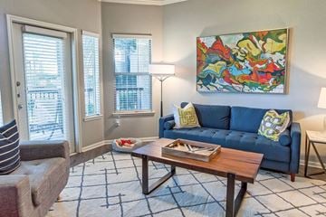 Allen apartment for rent - A living room with a blue couch and a painting on the wall.