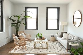 Milwaukee apartment for rent - A living room with a white couch, a coffee table, and a large plant.