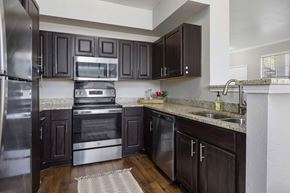 Roanoke apartment for rent - A kitchen with dark brown cabinets and stainless steel appliances.