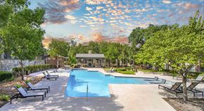 San Antonio apartment for rent - a swimming pool with trees and chairs around it