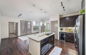 Plano apartment for rent - a kitchen with a center island and a stainless steel refrigerator