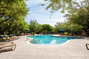 Austin apartment for rent - a swimming pool with chairs and umbrellas at the resort