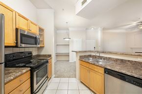 Austin apartment for rent - A kitchen with a black stove top oven and a black microwave.
