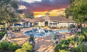Austin apartment for rent - A large building with a pool in front of it.