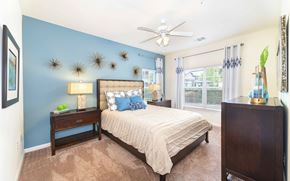 Austin apartment for rent - A bedroom with a bed, nightstand, and a ceiling fan.