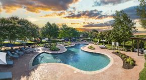 Austin apartment for rent - a swimming pool at a resort with trees and a sunset