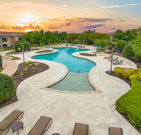 Round Rock apartment for rent - an aerial view of a swimming pool with a sunset in the background