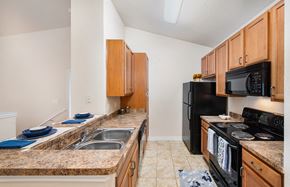 Round Rock apartment for rent - a kitchen with black appliances and granite counter tops