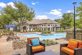 Irving apartment for rent - A poolside area with a house in the background.