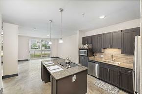 Irving apartment for rent - a kitchen with dark cabinets and a large island in the middle