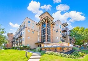 Irving apartment for rent - a large building with a sign outside of it on a sunny day