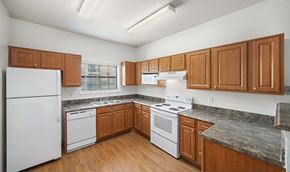 Austin apartment for rent - a kitchen with white appliances and wooden cabinets