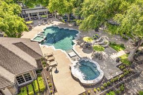 Austin apartment for rent - an aerial view of a swimming pool and a resort style pool and yard with trees