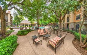 Austin apartment for rent - a courtyard with tables and chairs in front of a building