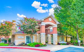 Round Rock apartment for rent - a building with a red brick facade and trees