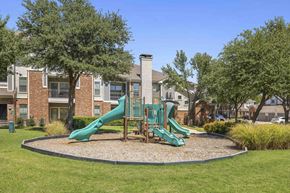 Roanoke apartment for rent - A playground with a green slide and a red brick building in the background.
