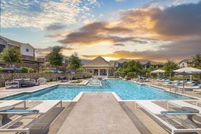 Roanoke apartment for rent - A large outdoor swimming pool surrounded by lounge chairs and umbrellas.